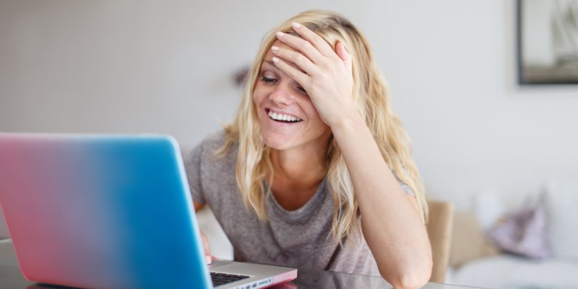 带着笔记本电脑的金发女人忘了在网上商店买东西，捂着脸