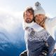 一对恩爱的情侣一起在雪地里玩耍。寒假在山上。男男女女穿着针织服装在周末玩。